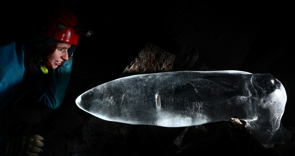 Woman looking at an ice formation in a cave